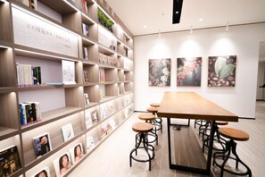 Una biblioteca moderna con estanterías, una mesa larga y taburetes.