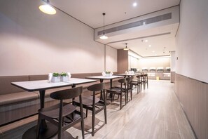 Un interior de restaurante moderno con asientos tipo cabina, mesas y sillas.