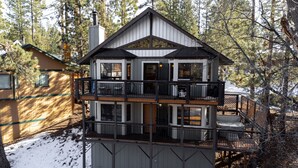 A multi-story cabin with a balcony, surrounded by trees and snow. - Hot tub, bbq, 2 fireplaces, 5 mins to slopes & lake (Big Bear Lake)