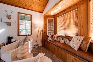 A cozy cabin interior with a wooden bench, a lamp, and a wall-mounted decorative piece.