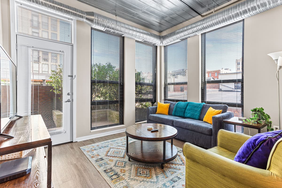 Una sala de estar moderna con un sofá, una mesa de centro y una mesa de comedor.