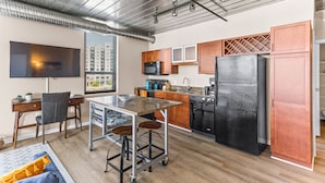 Una cocina moderna con una isla central, electrodomésticos de acero inoxidable y armarios de madera.