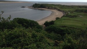 A coastal landscape with a sandy beach, a golf course, and a body of water. - 48A South Snowdon Wharf (Porthmadog)