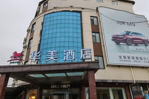 Een hotel met een opvallende blauwe gevel en een bord waarop een auto wordt aangeboden.