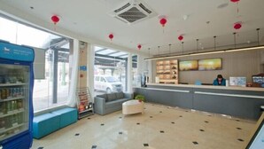 A hotel reception area with a counter, seating, and a vending machine. - Huamei Hotel (Linyi Luozhuang District Government) (Linyi)