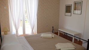 A bedroom with a bed, a bedside table, a bench, and two framed pictures on the wall. - Apartment Casa Monte Mulini 1/1 (Rovinj)
