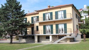 A two-story building with a stone base, green shutters, and a balcony. - Apartment Casa Monte Mulini 1/1 (Rovinj)