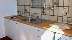 A kitchen with two sinks, a wooden countertop, and a tiled backsplash. - Apartment Casa Monte Mulini 1/1 (Rovinj)