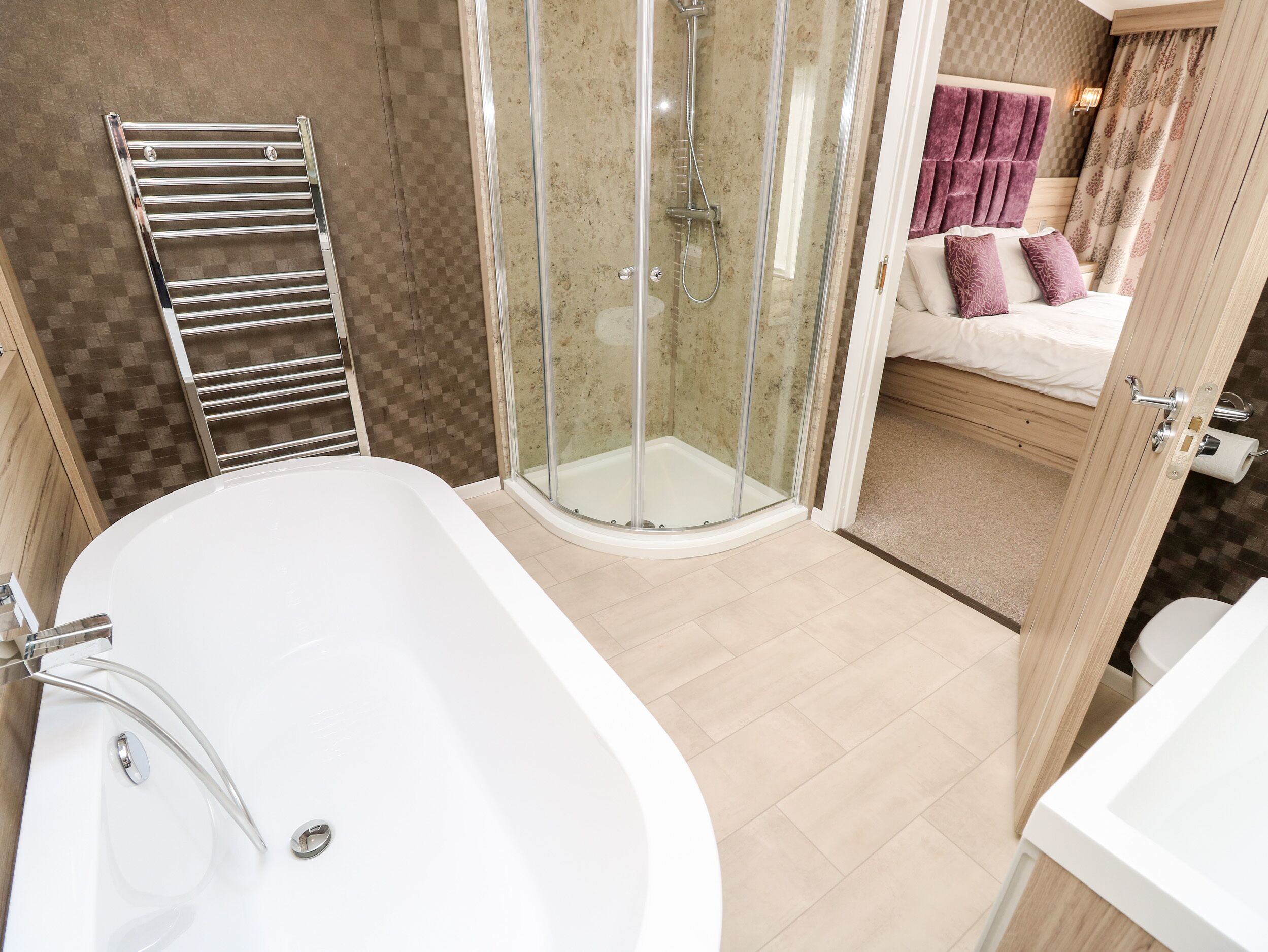 A modern bathroom with a glass-enclosed shower, a freestanding bathtub, and a wooden vanity.