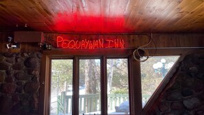 Huone, jossa on kiviseinä, puukatto ja ikkuna, josta avautuu näkymä puihin ja aitaan.