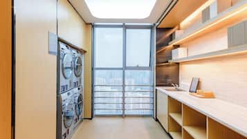 A modern laundry room with a skylight, a large window, and a counter with a sink.
