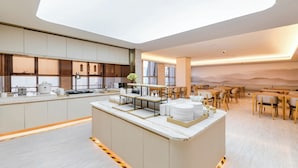 Un hall d’hôtel moderne avec un îlot central, un espace salon et une grande fenêtre.