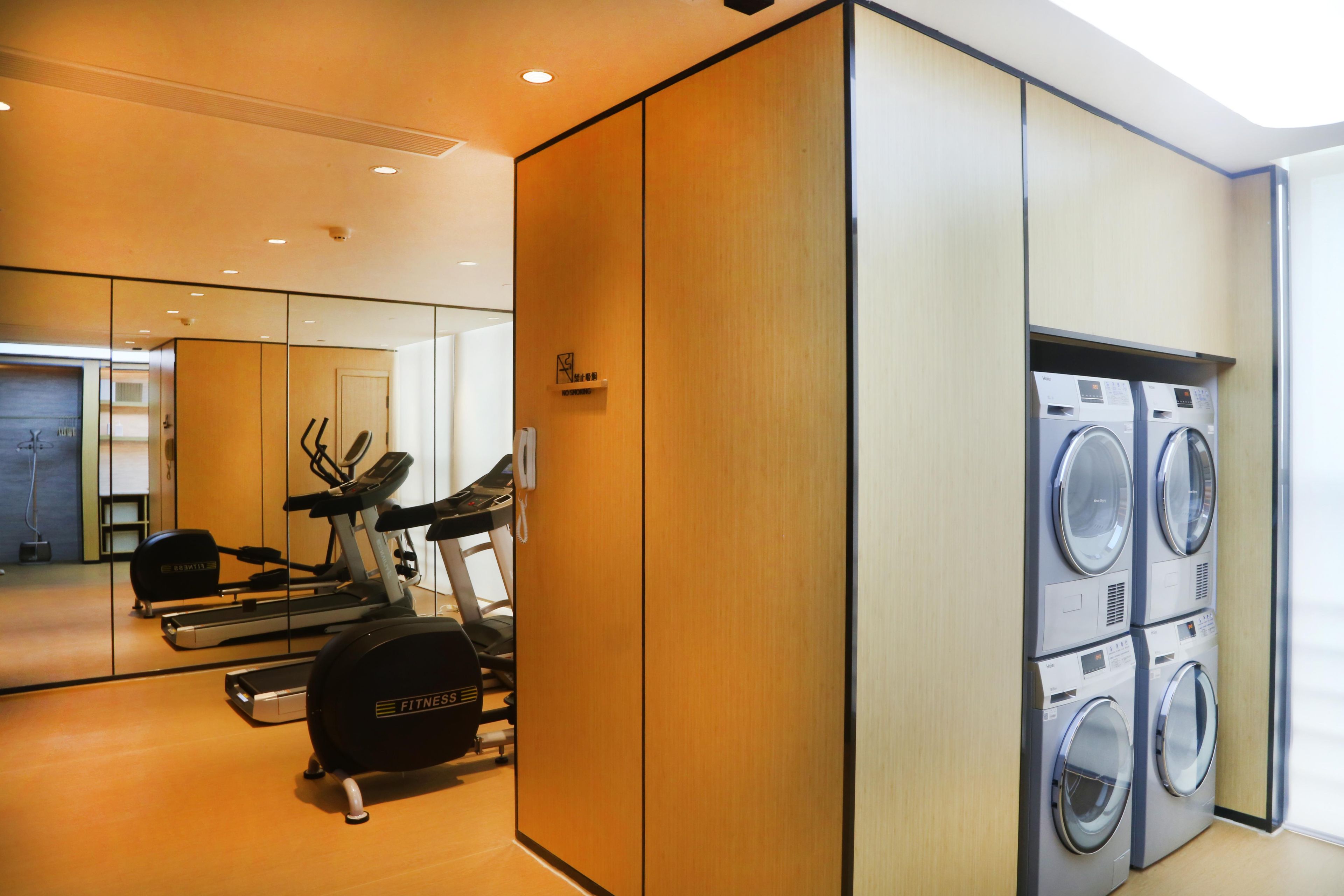A gym with exercise equipment and a washing machine.