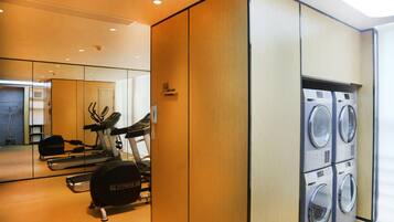 A gym with exercise equipment and a washing machine.