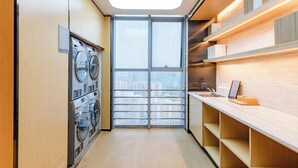 Une buanderie moderne dotée d’une lucarne, d’une grande fenêtre et d’un plan de travail avec un évier.