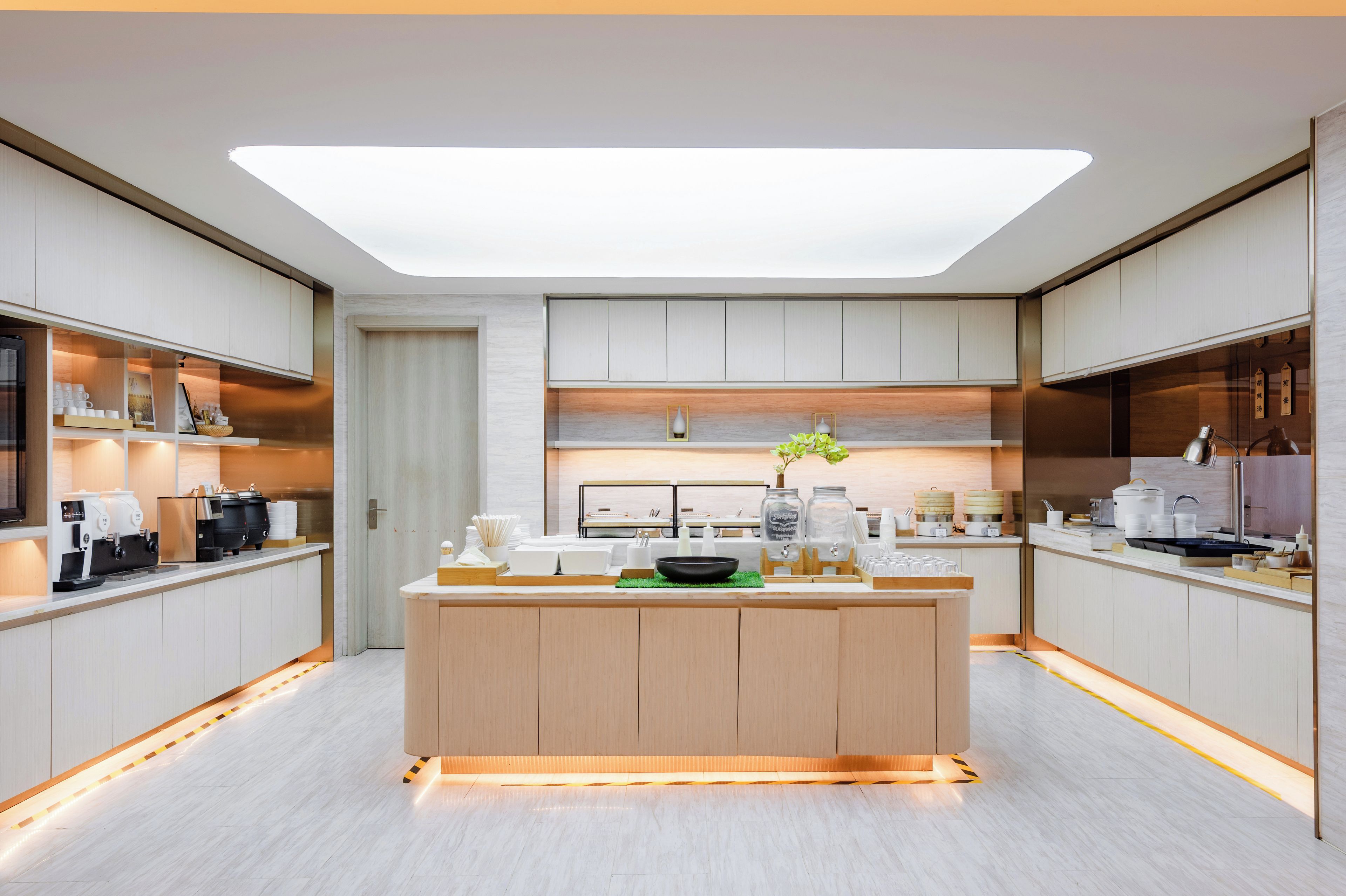 A modern kitchen with a central island, built-in appliances, and a skylight.