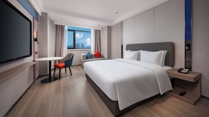 Una camera d'albergo moderna con un letto grande, una scrivania e una sedia.