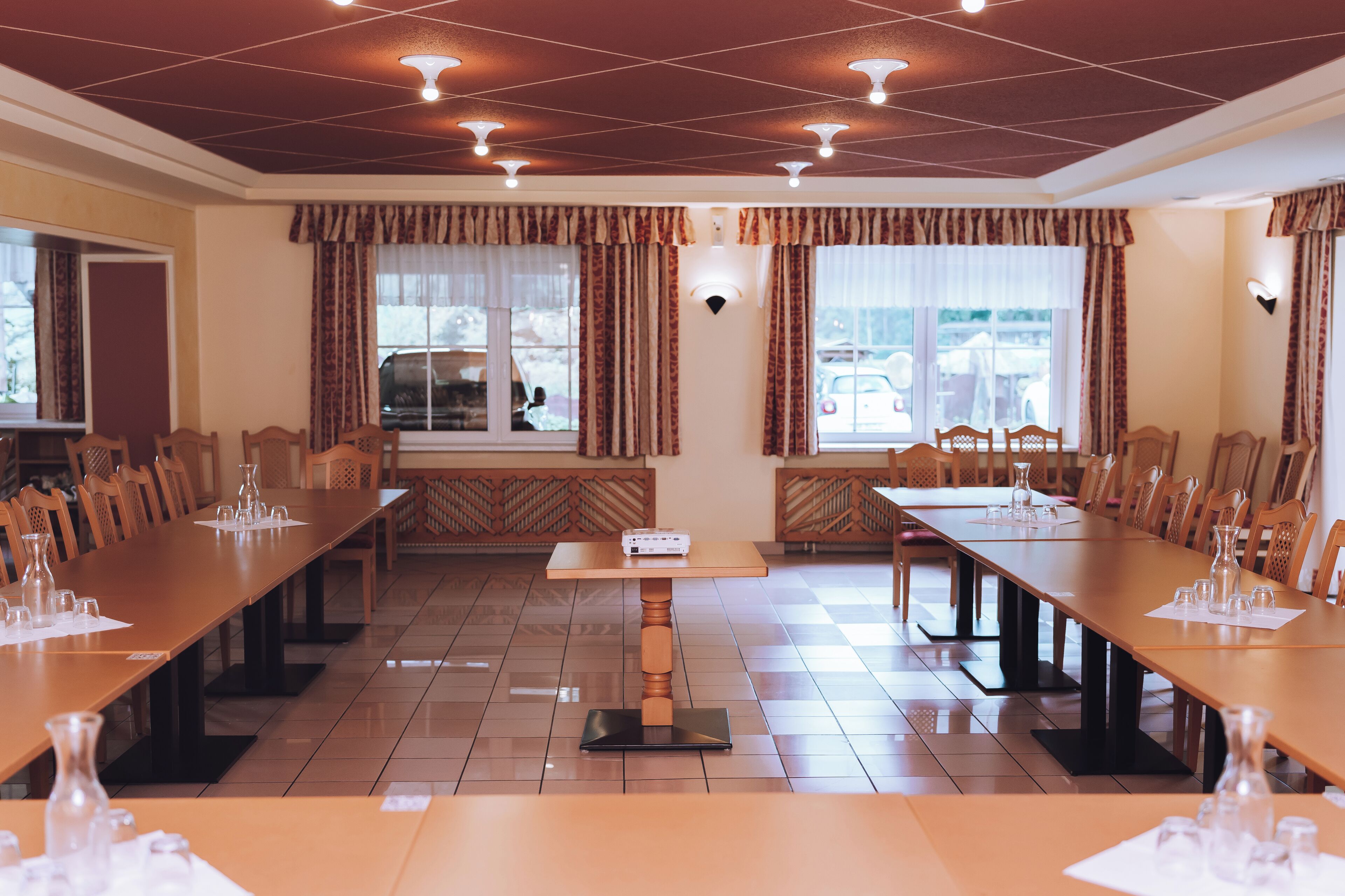 A conference room with long tables, chairs, and a projector.