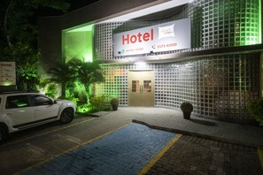 A hotel with a modern facade, a signboard displaying the name and contact information, and a paved entrance area with a parked car. - Hotel Picks Ibirapuera (São Paulo)