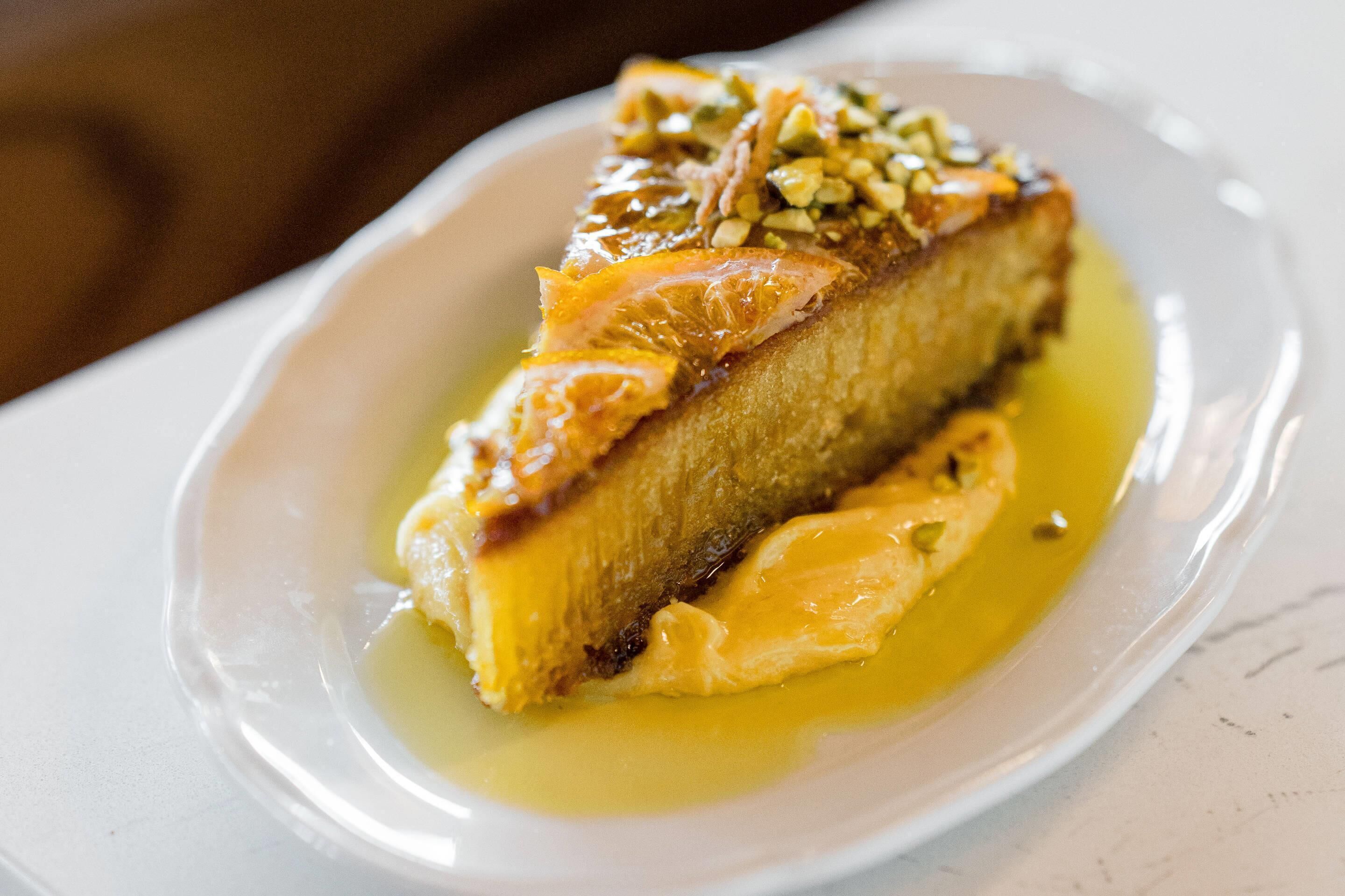 A dessert on a white plate with a glossy sauce.