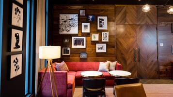 A modern interior with a red sofa, two round tables, and a floor lamp.