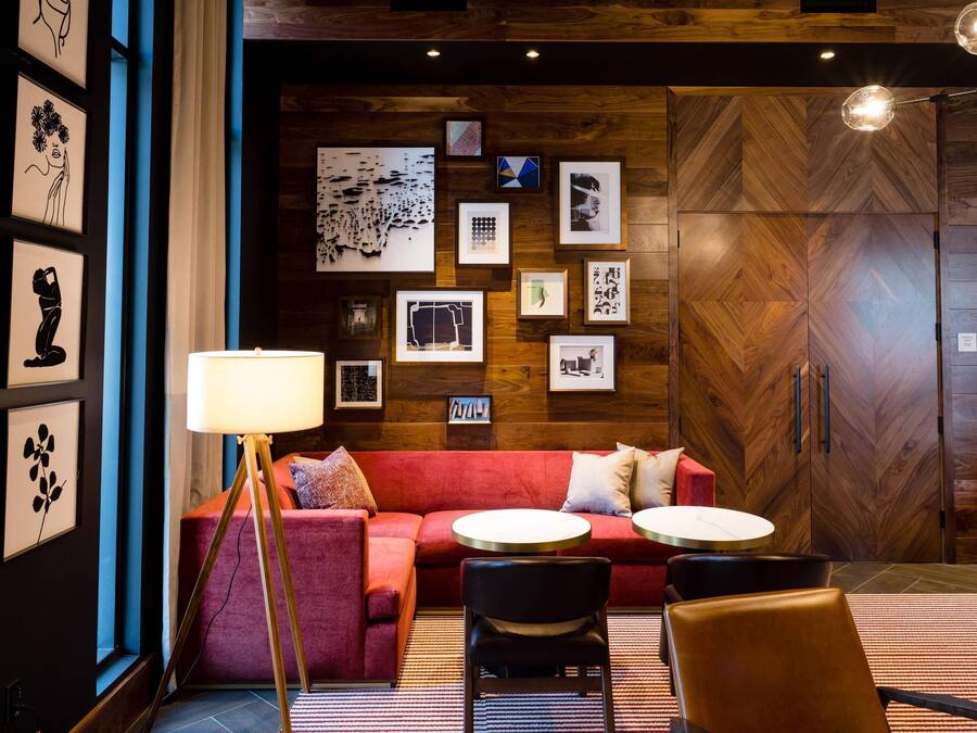 A modern interior with a red sofa, two round tables, and a floor lamp.