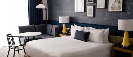 Ein Hotelzimmer mit einem großen Bett, einer Couch, einem kleinen Tisch und zwei Lampen.