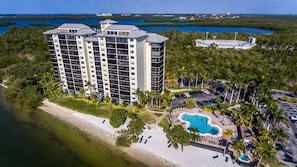 Ein Hochhaus-Hotel mit mehreren Etagen, einem Schwimmbad und einer Strandanlage.