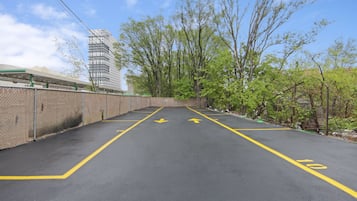 A parking lot with directional arrows and a speed limit sign.