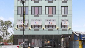 A multi-story hotel with a modern facade, multiple windows, and a visible entrance. - Hotel 365 Bronx (Bronx)