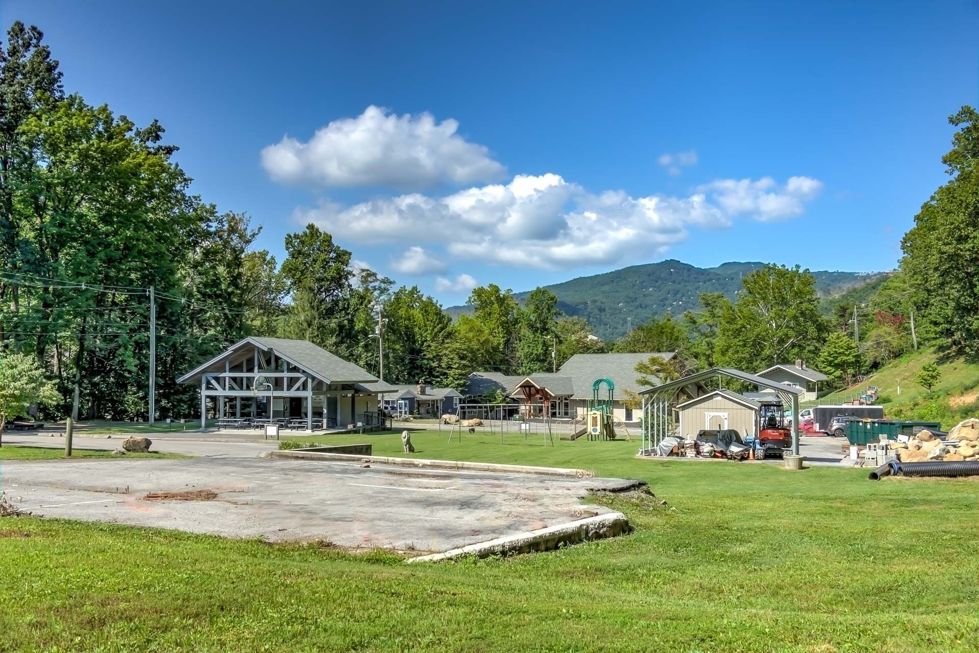 A park with picnic shelters, a playground, and a parking area.