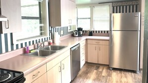 Una cocina compacta con fregadero, estufa y refrigerador.