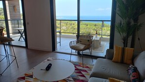 A spacious living room with a large sliding glass door leading to a balcony with a view of the sea. - A charming setting with the sea in full view! (Pietrosella)