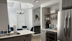 Una cucina moderna con lavastoviglie integrata, un frigorifero cantinetta per vini e un frigorifero in acciaio inossidabile.