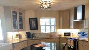 A kitchen with a large island, a built-in oven, and a microwave. - Cheerful 3 bedroom house with a heated pool (Naples)