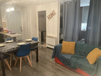 le coin salon, la cuisine et la chambre derriĂšre les rideaux