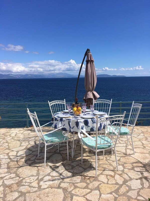 A table set outdoors with a view of the sea.