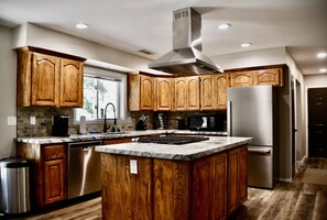 Una cocina moderna con armarios de madera, electrodomésticos de acero inoxidable y una isla grande.