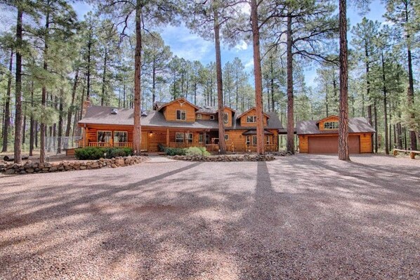 A large log cabin with multiple rooms, surrounded by a forest. - The Monarch (Pinetop-Lakeside)