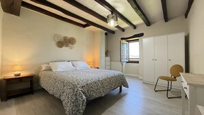 Une chambre à coucher avec un lit, des lampes de chevet, une armoire et une chaise.