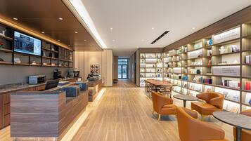 A modern library with a reception desk, seating area, and bookshelves.