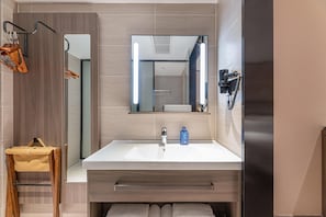 A modern bathroom with a large mirror, a sink, and a towel rack. - Hanting Hotel (Changzhou)
