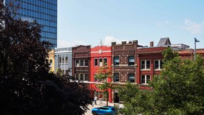Una fila di edifici a più piani con diversi stili architettonici, tra cui un moderno edificio in vetro a sinistra e edifici più antichi in mattoni al centro e a destra.