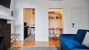 A living room with a blue sofa, a fireplace, and a bookshelf. - Walkable to Huntington Center, Fifth-Third Field and the Convention Center! (Toledo)