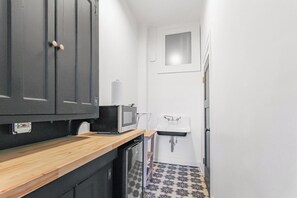 Une cuisine compacte équipée d’un four à micro-ondes, d’un évier et d’un meuble de rangement.