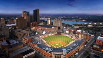 A baseball stadium surrounded by urban buildings, with a river in the background.