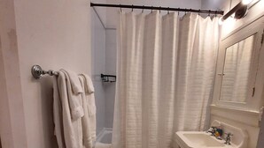 A small bathroom with a toilet, sink, and shower. - EZ Check-in and Check-Out, Perfect for a Night Downtown! (Toledo)