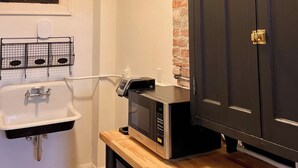A kitchen with a microwave, a sink, and a cabinet. - EZ Check-in and Check-Out, Perfect for a Night Downtown! (Toledo)