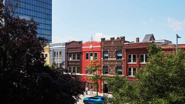 A row of multi-story buildings with a mix of architectural styles, including a modern glass building on the left and older brick buildings in the center and right. - EZ Check-in and Check-Out, Perfect for a Night Downtown! (Toledo)