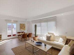 Un salon moderne avec un canapé, une table basse et un coin repas.